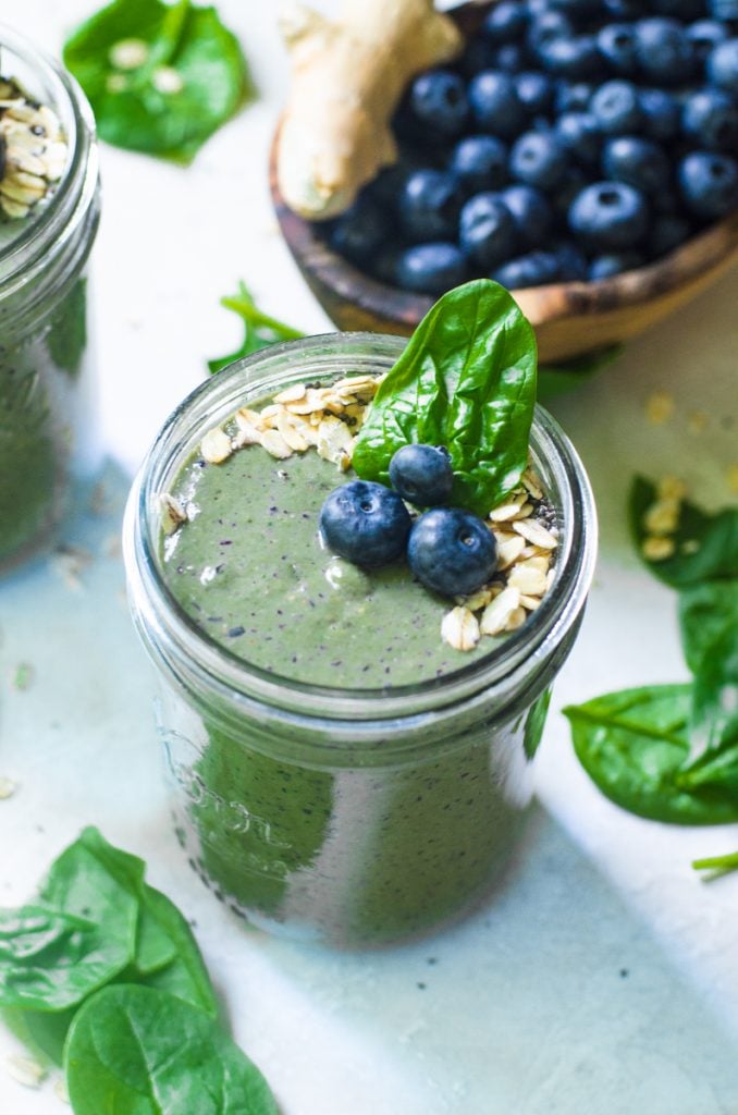 A mason jar of smoothie next to ingredients.