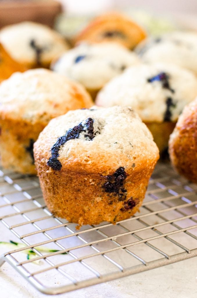 Close up of blueberry zucchini muffins on a cooling rack.