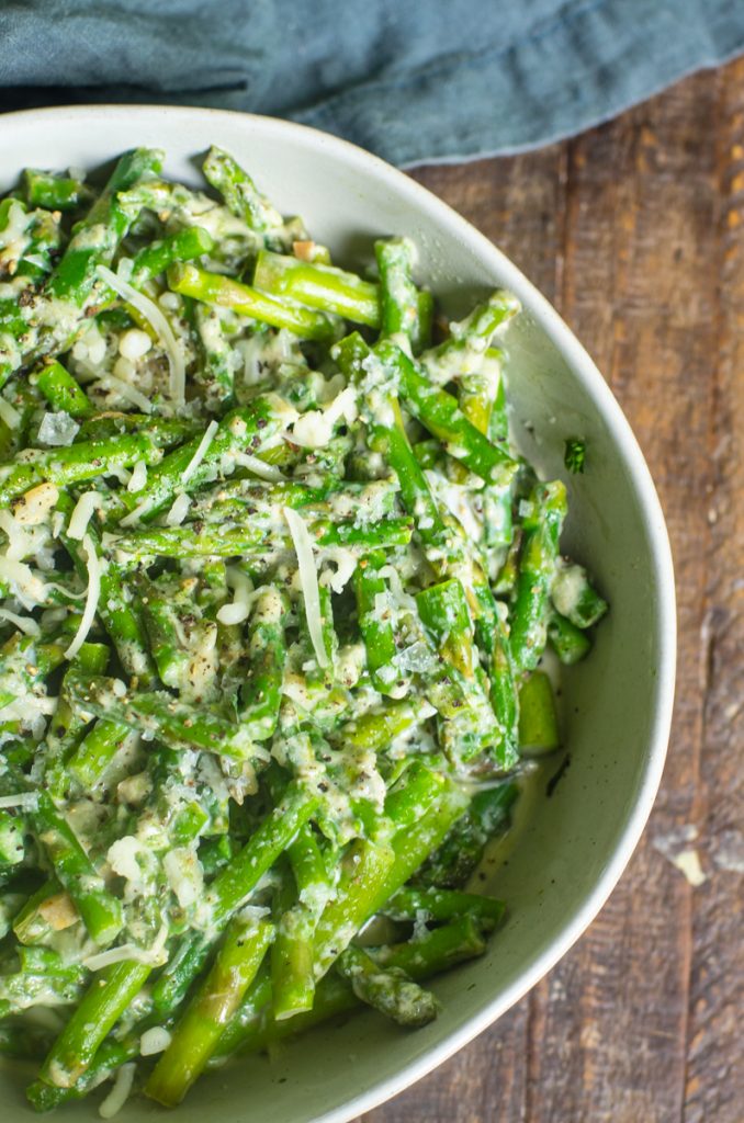 A bowl of cut asparagus in a cream sauce.