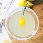 overhead view looking into a lavender martini garnished with lemon and lavender stems.