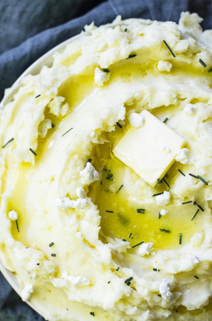 Close up of wells of melted butter and chives.