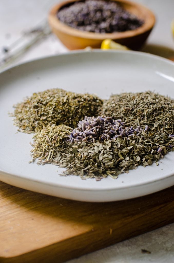 Dried herbs on a plate next to each other.