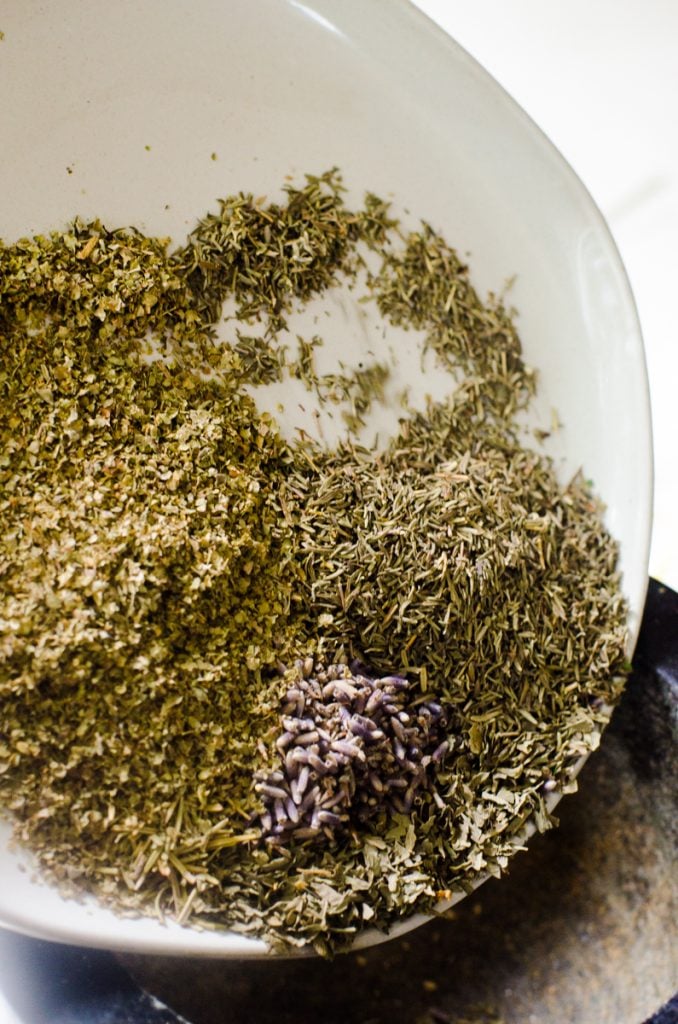 A plate pouring herbs into a mortar and pestle.