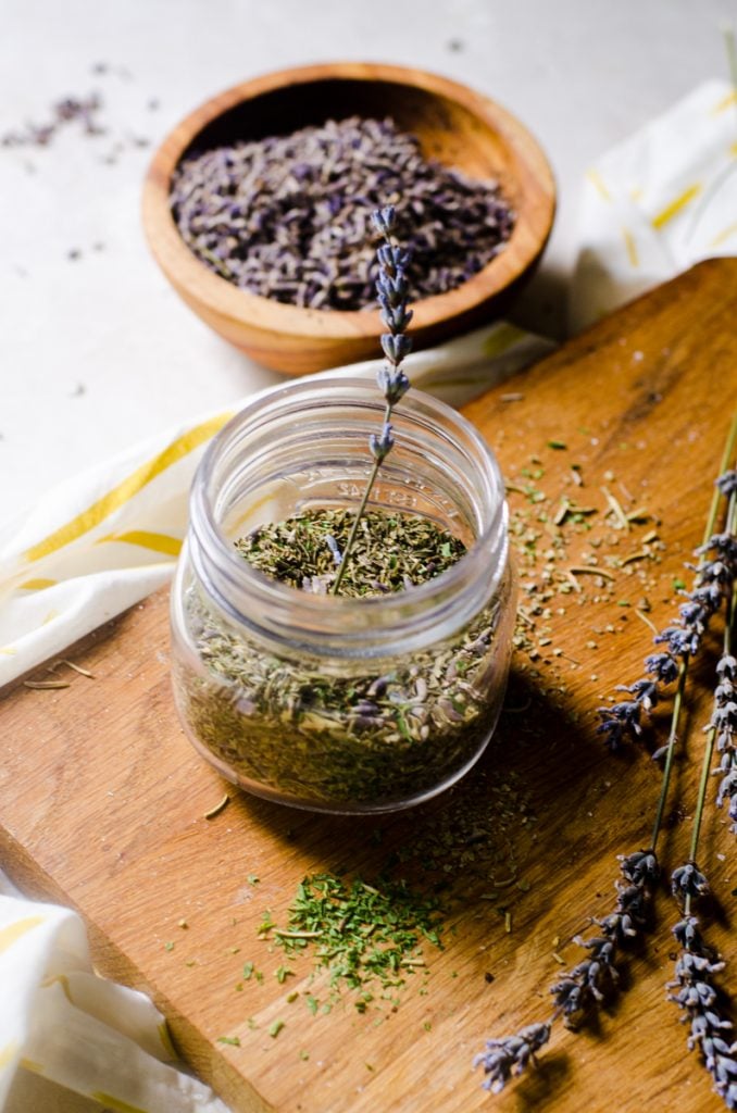 Dried lavender stem sticking out of a jar of herbs.