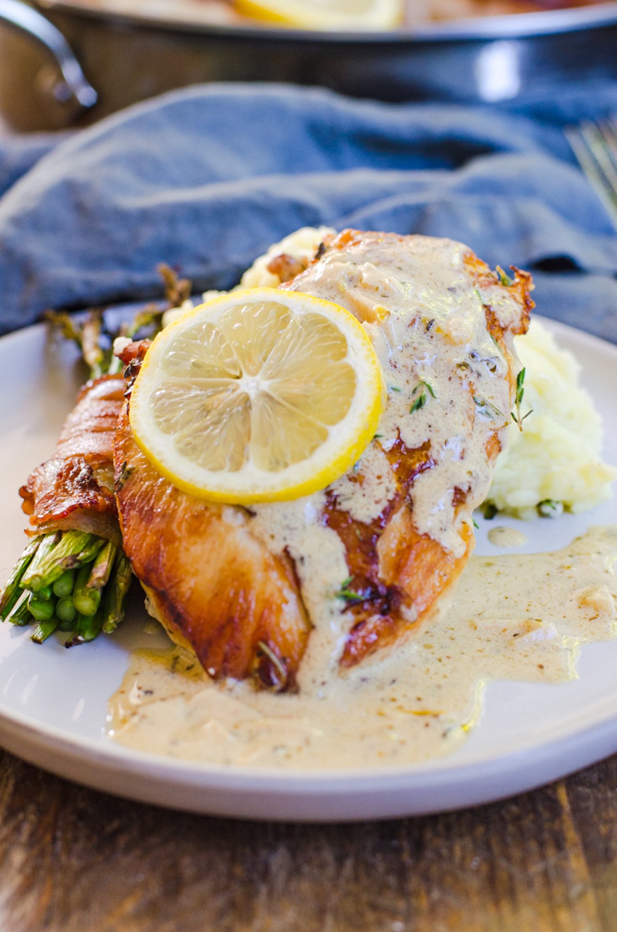 Herbs de Provence chicken with lemon cream sauce next to asparagus and mashed potatoes.
