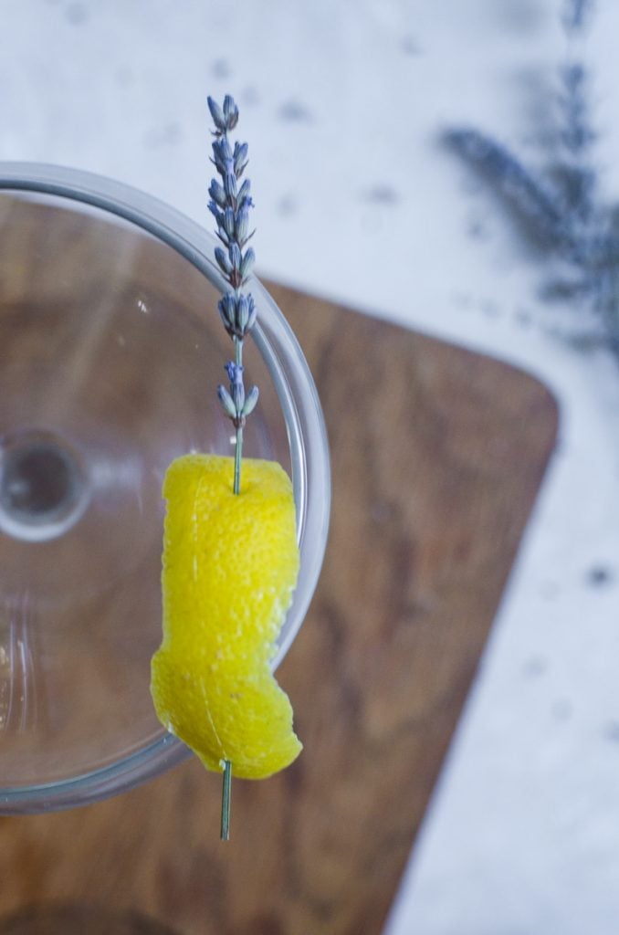 A lemon and lavender cocktail garnish on a couple glass.