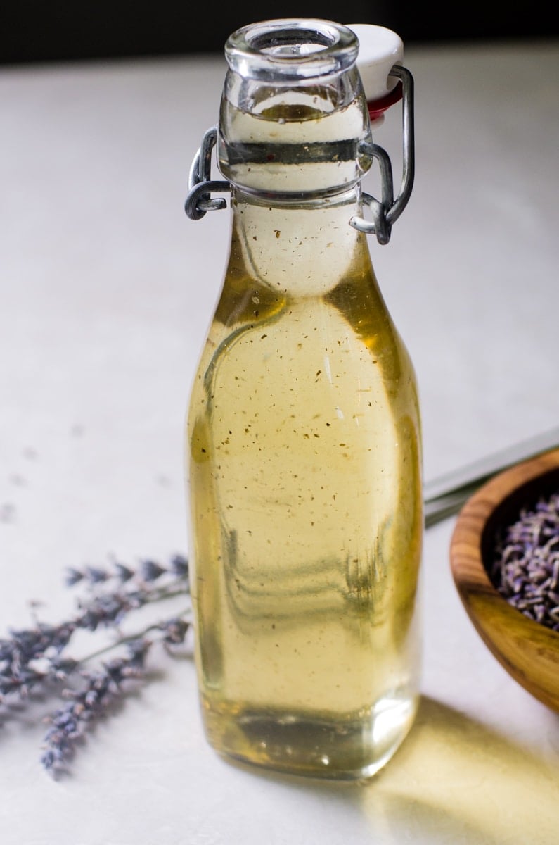 Close up of lavender simple syrup inside of a glass jar.