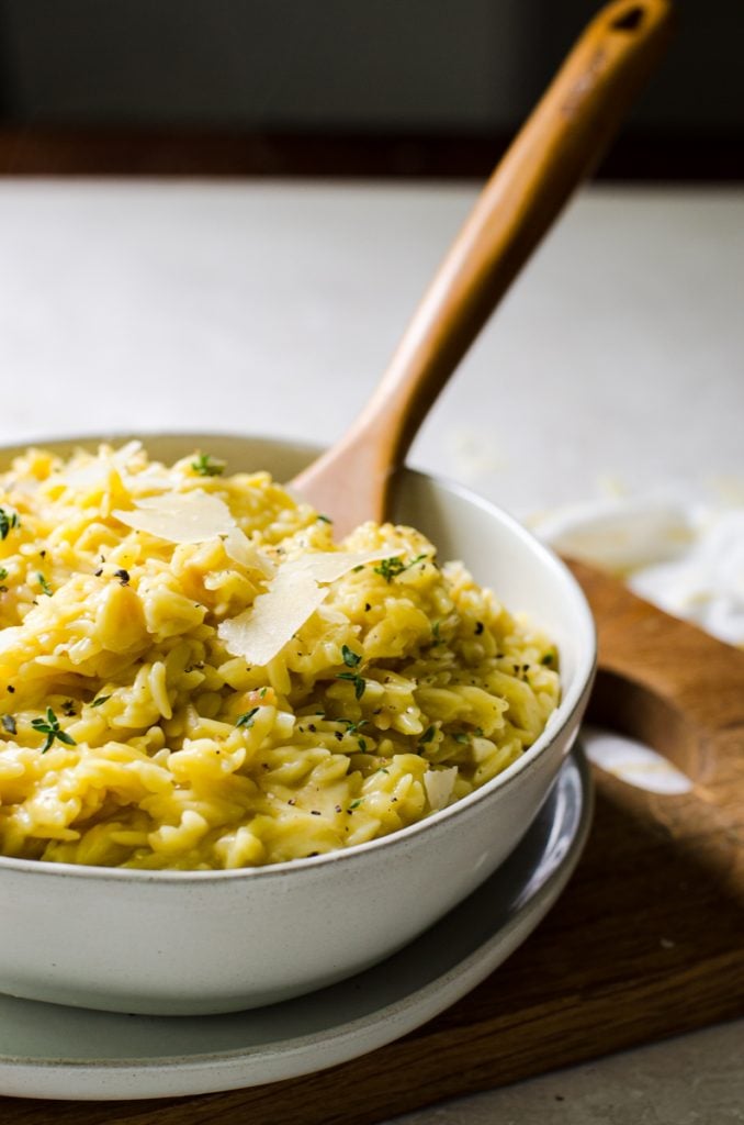 shaved parmesan cheese on a bowl of pasta.