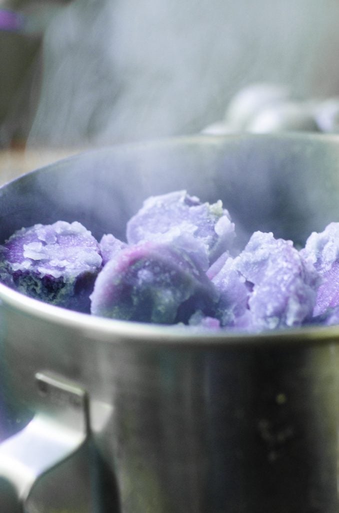 Steam coming out of a mixing bowl of cooked potatoes