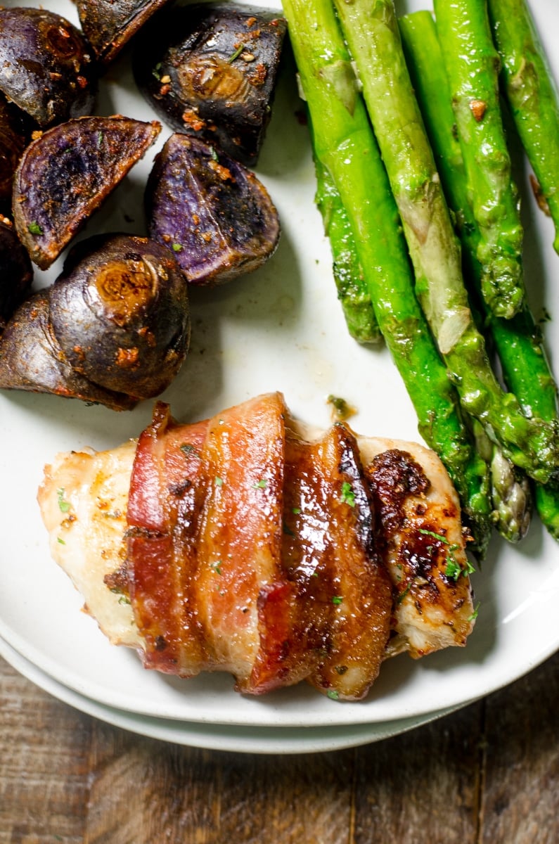 Close up of crispy bacon wrapped around chicken thighs.