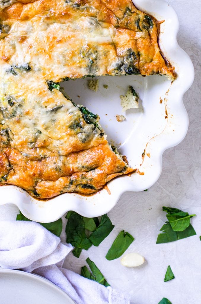 A ruffled pie dish of golden brown egg bake.