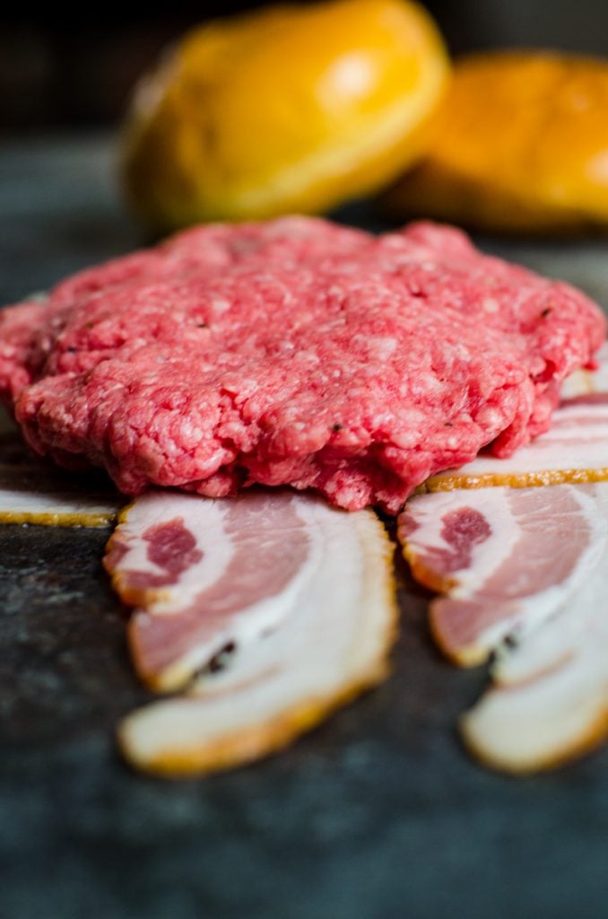 a pinched and flatted together cheese stuffed burger patty on bacon strips.