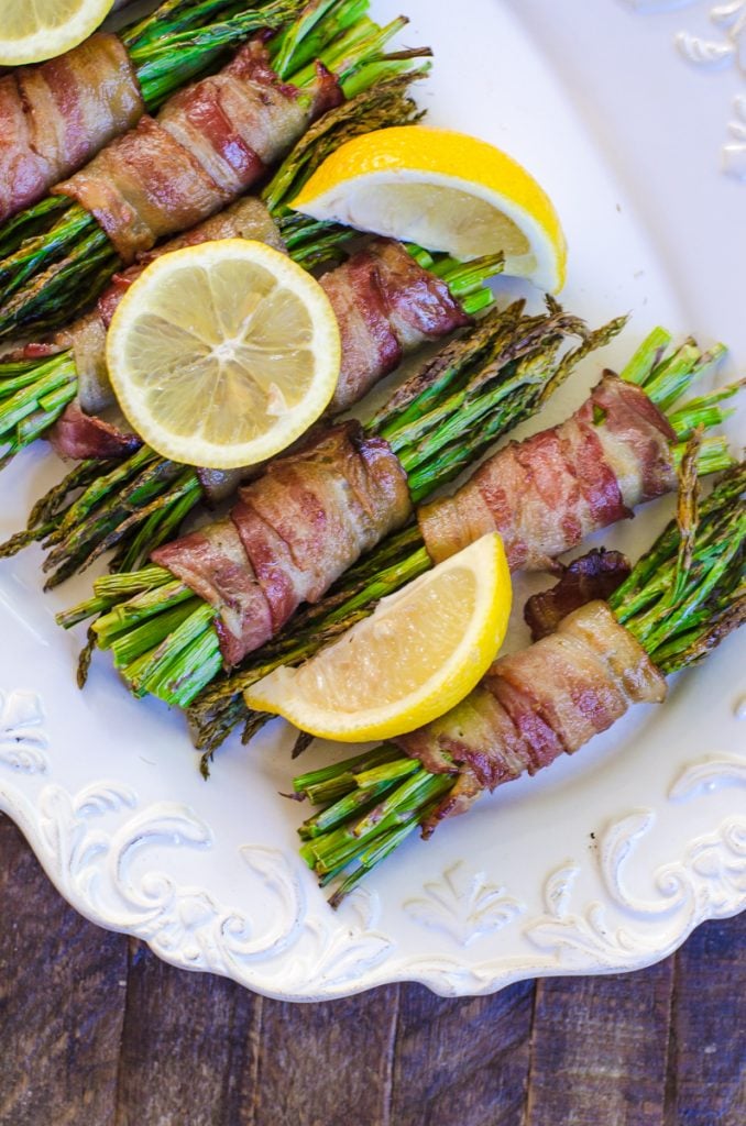 Close up of cooked asparagus garnished with lemons.