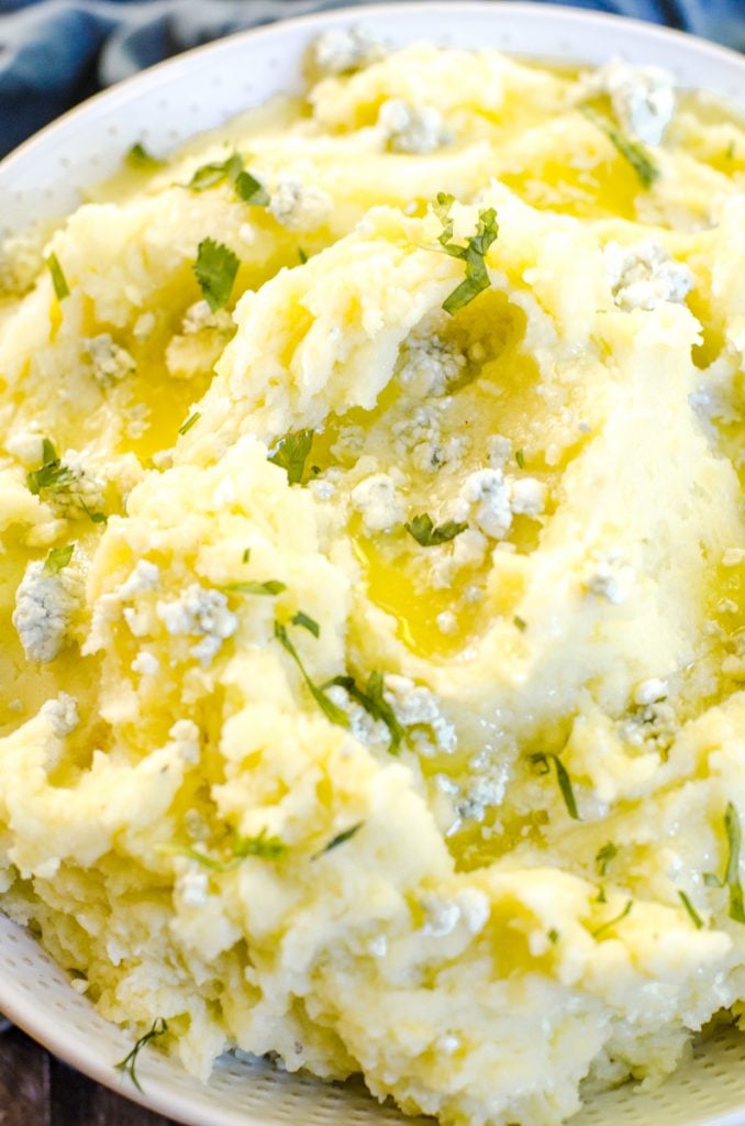 Melted butter and blue cheese garnish on mashed potatoes.