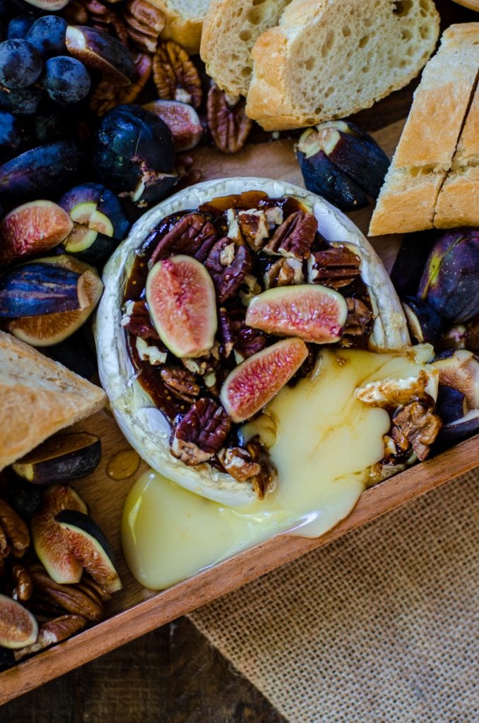 overhead view of baked brie spilling out of the wheel.