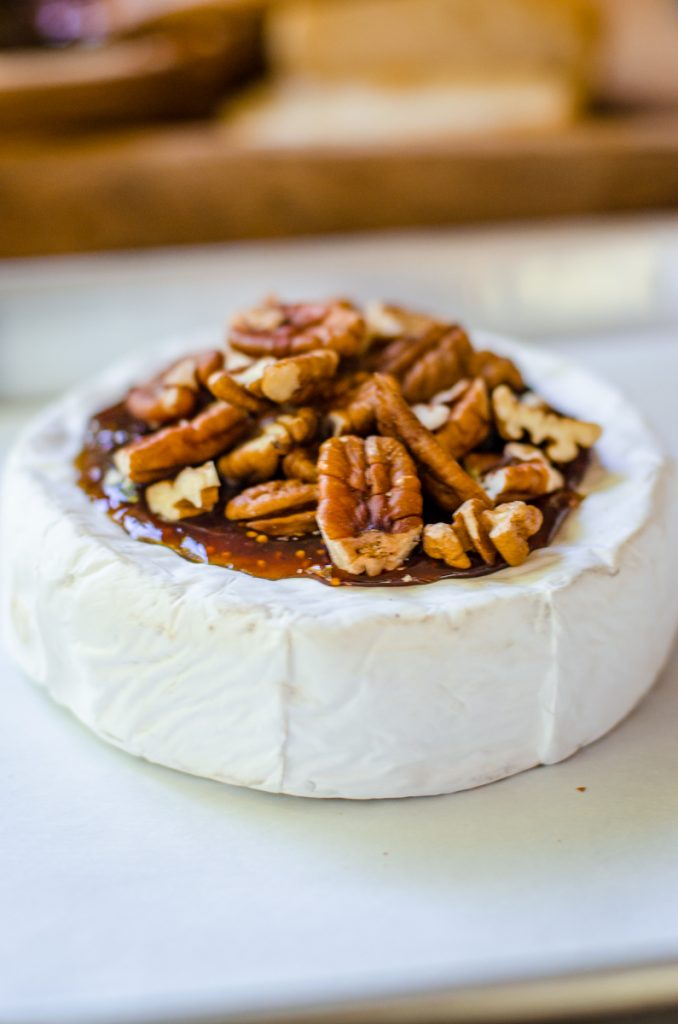 Pecans piled high on a wheel of brie.