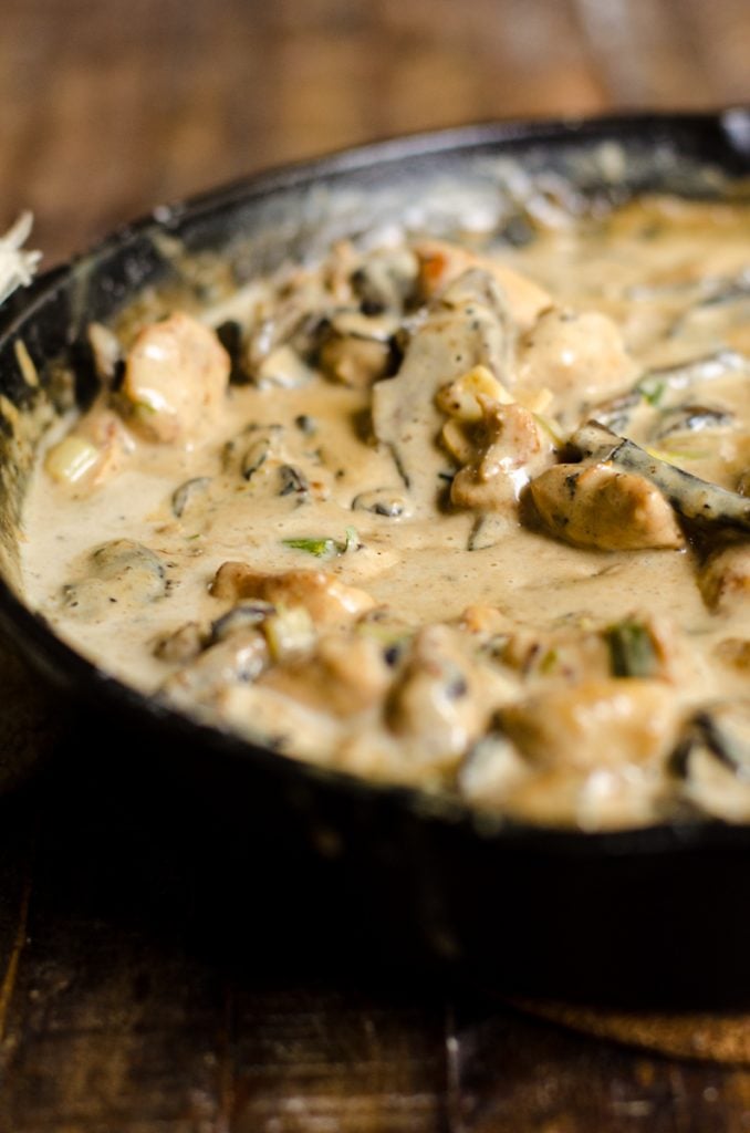 A cream sauce being simmered in a pan of meat and vegetables.