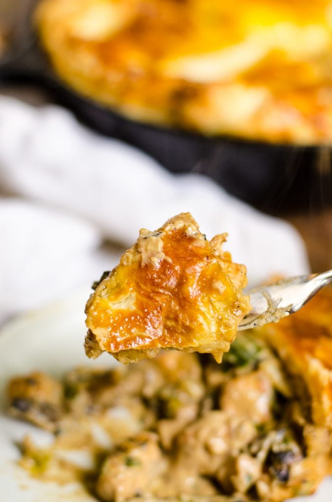 A bite of chicken and mushroom pie on a fork.