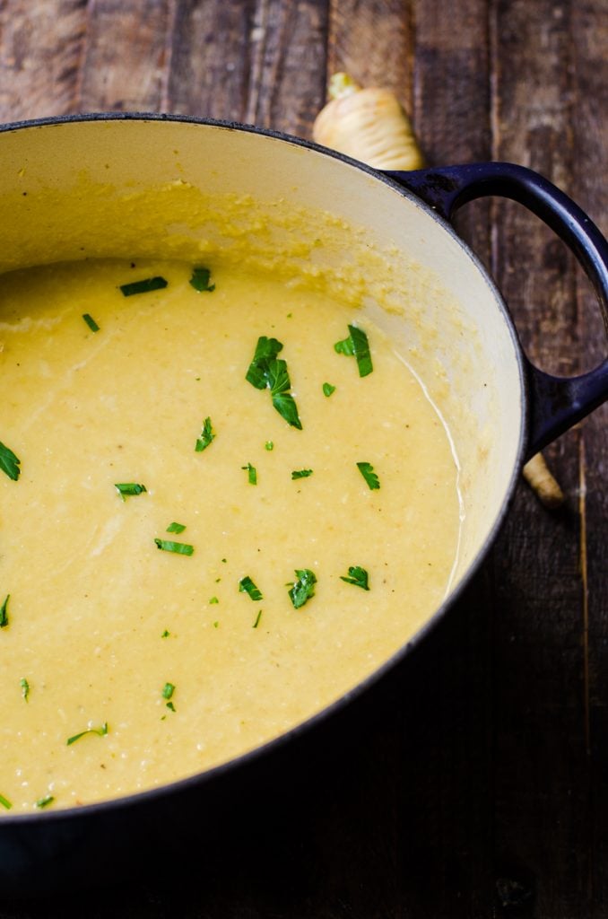 Inside of a dutch oven of creamy parsnip soup.