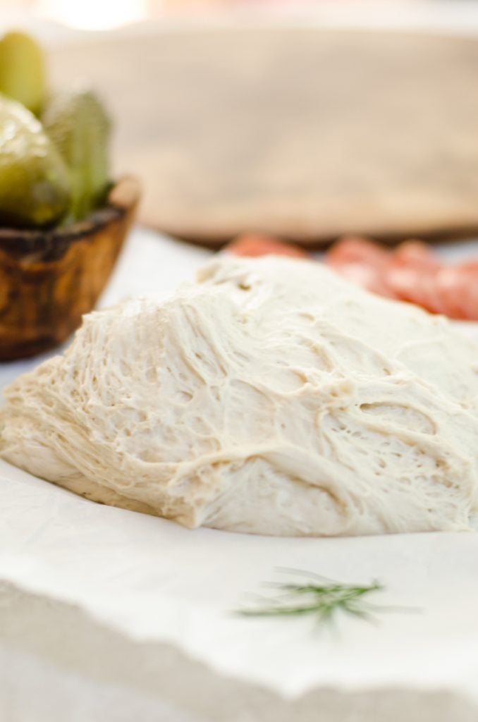 Pizza dough on parchment paper.