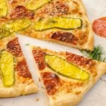 A slice of dill pickle pizza pizza separated from the whole pie.