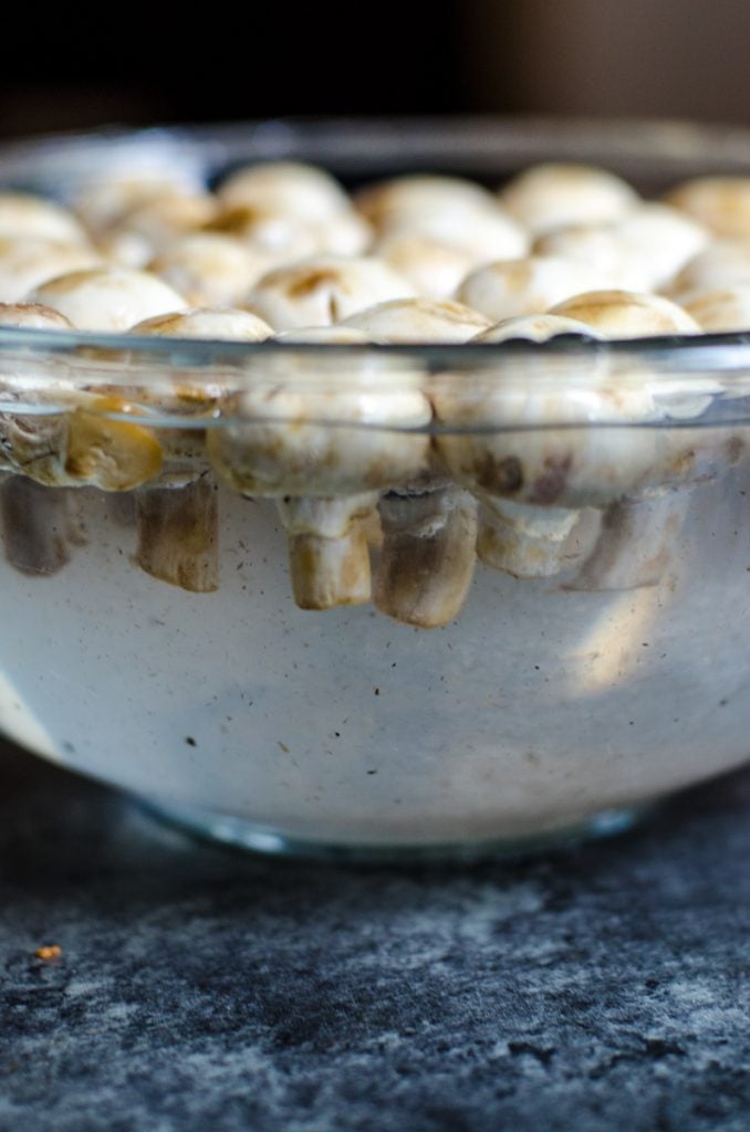 The dirt coming off of mushrooms while being cleaned.