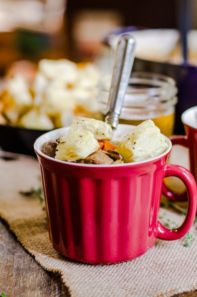 A bowl of stew with puff pastry croutons poking out the top.