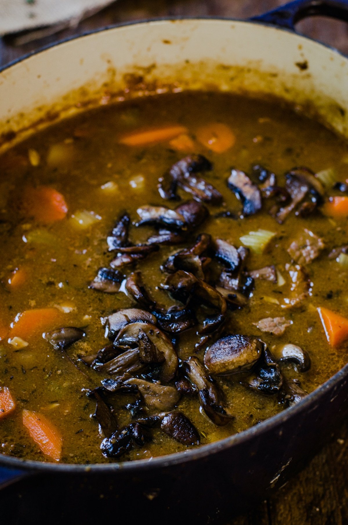 mushrooms being added to steak and ale soup.