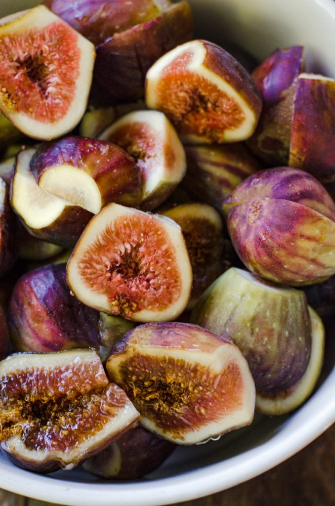 Close up of a bowl of halved figs.