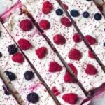 Side by side frozen green yogurt bars topped with fresh berries and cranberry seeds.