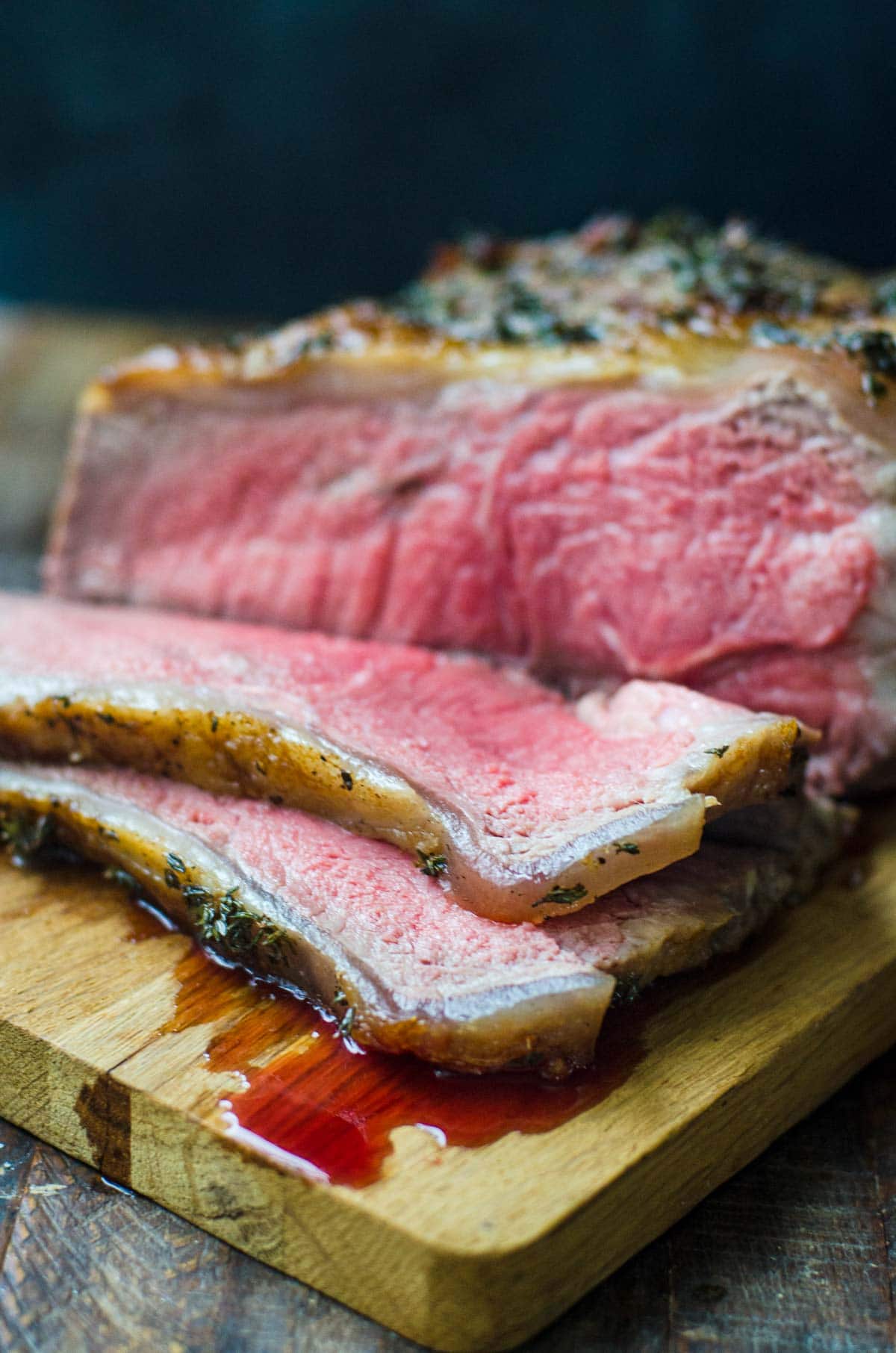 Sliced New York strip roast on a cutting board.