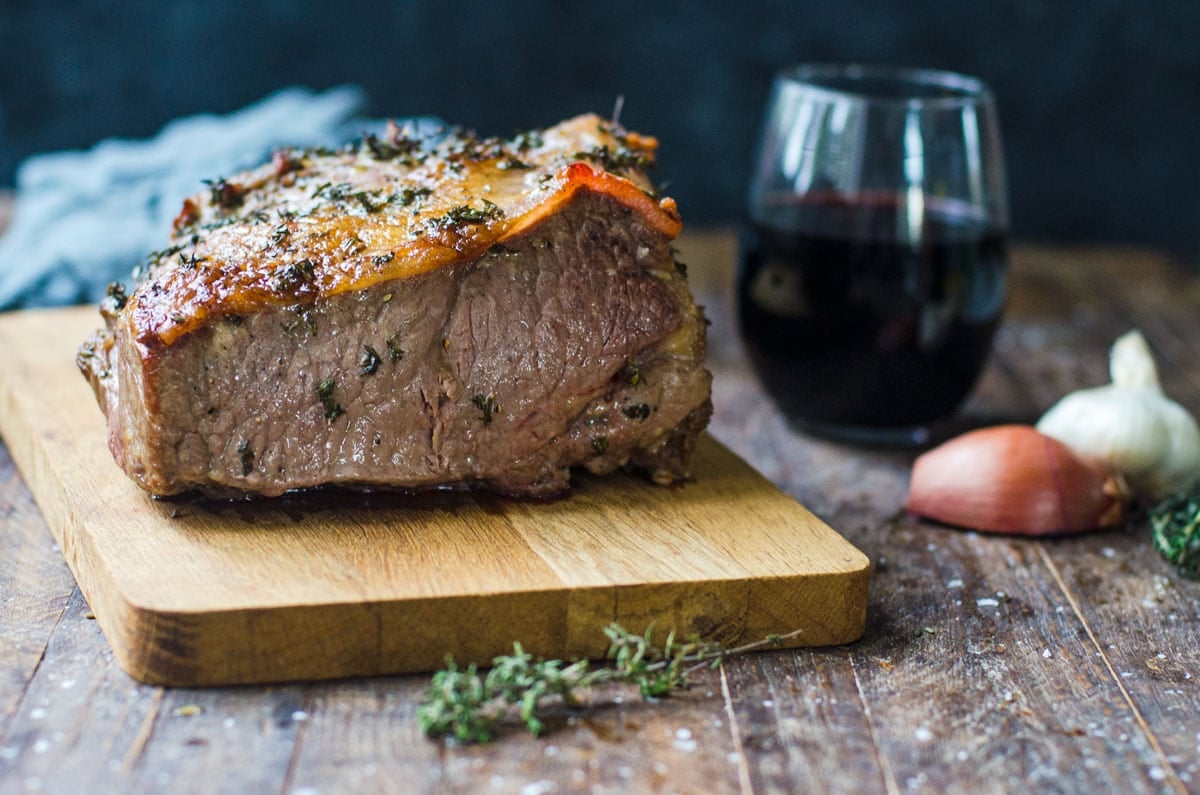 Cooked New York strip roast on a cutting board.