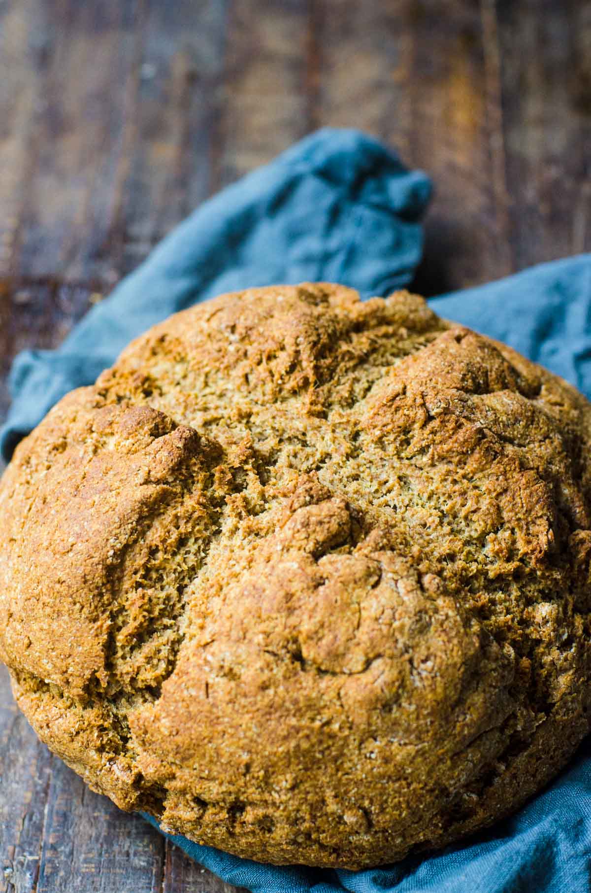 A loaf of freshly made soda bread on a blue napkin.