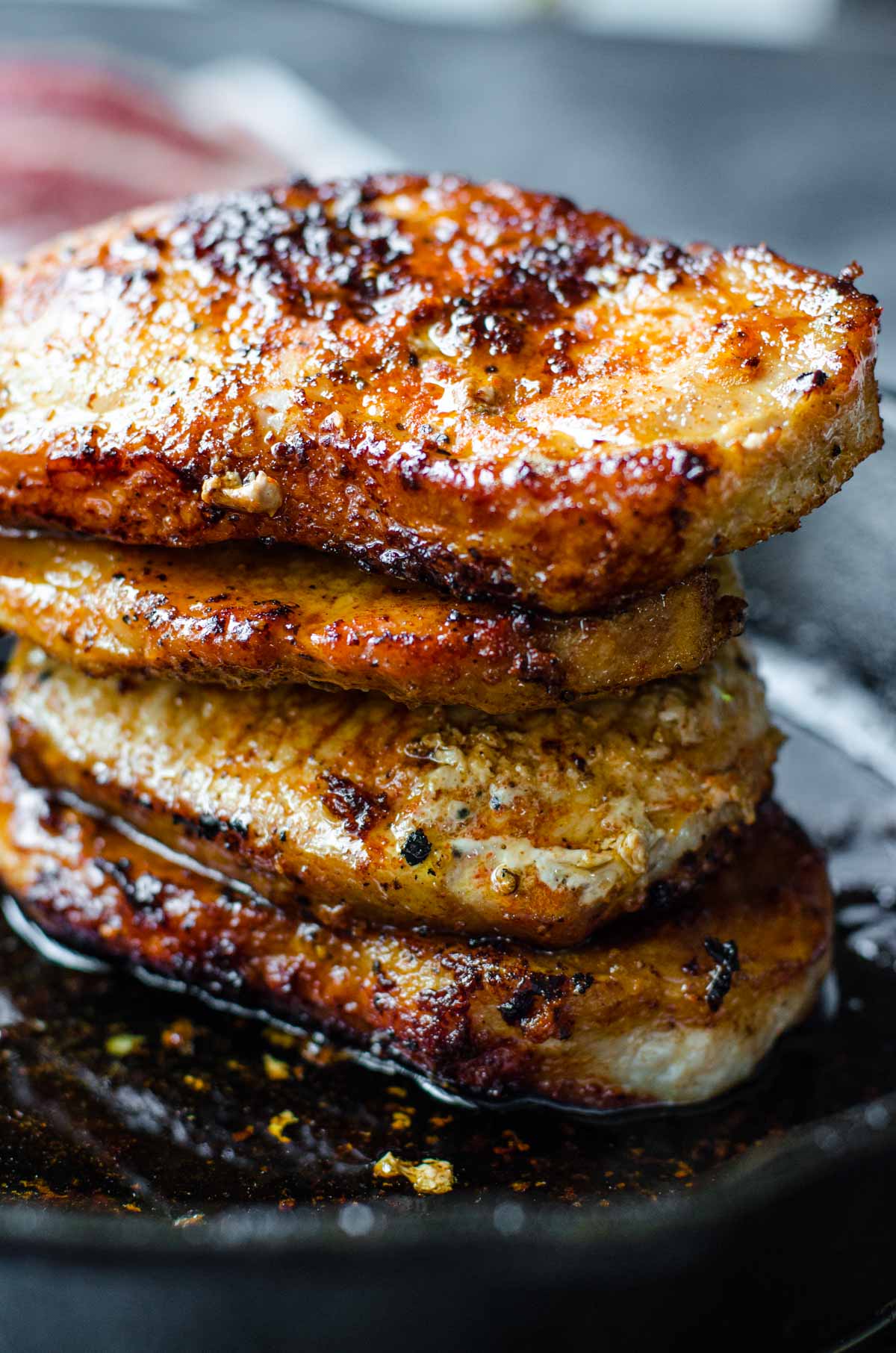 A stack of pork chops showing the fatty edge golden brown.