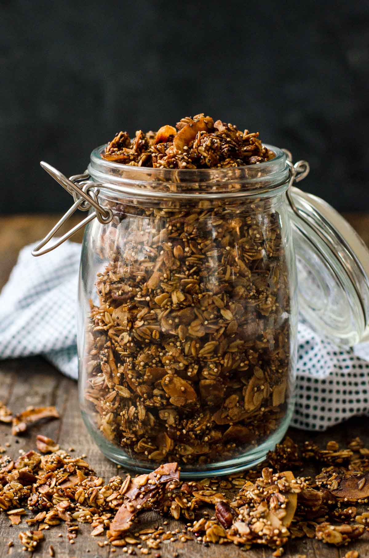 A clear jar of high protein granola on a counter.