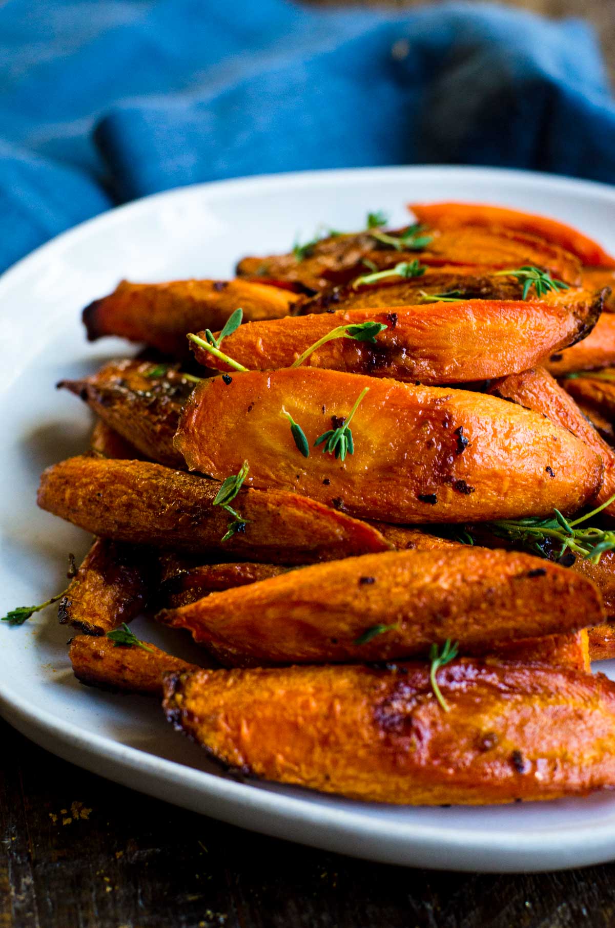 A plate of roasted carrots with fresh thyme.