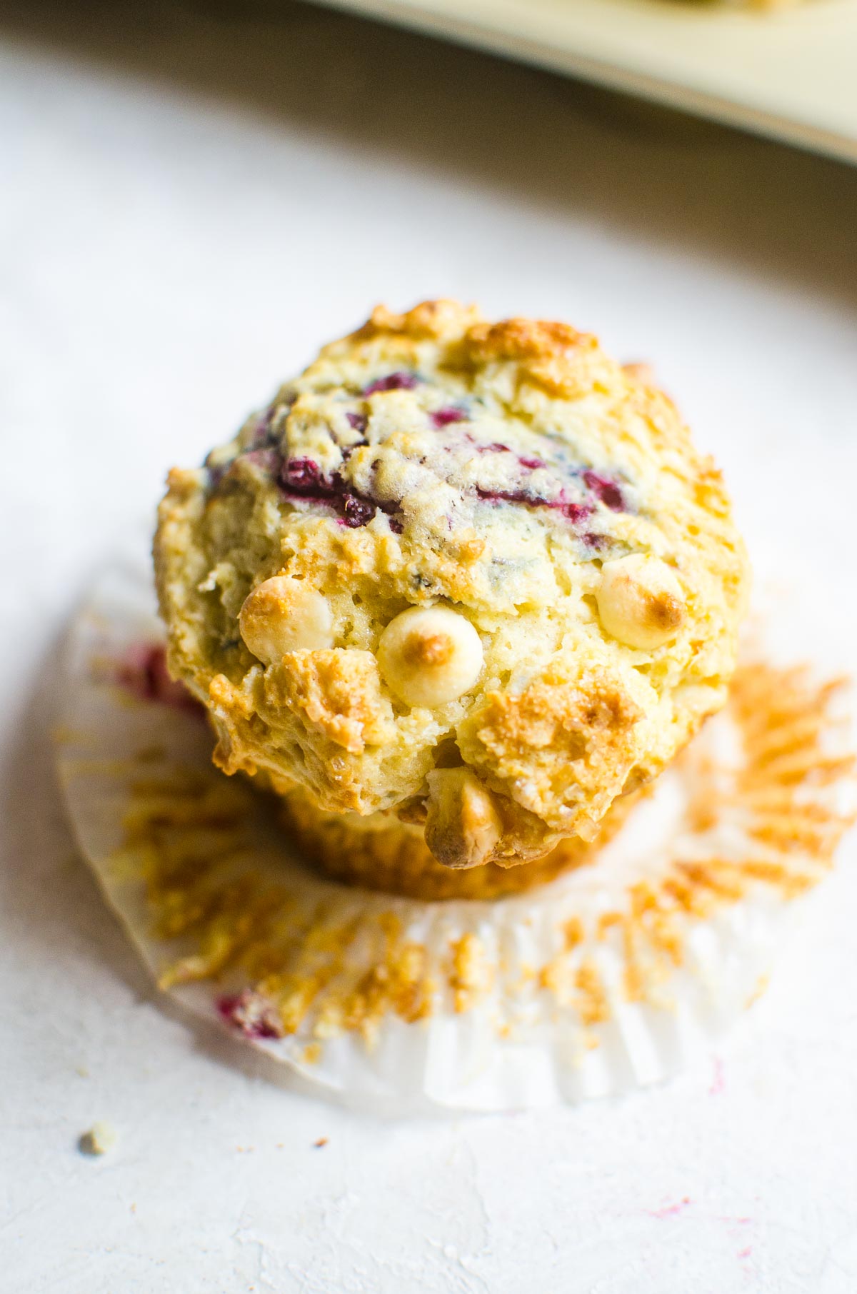 Overhead view of raspberry muffin showing toasted white chocolate.