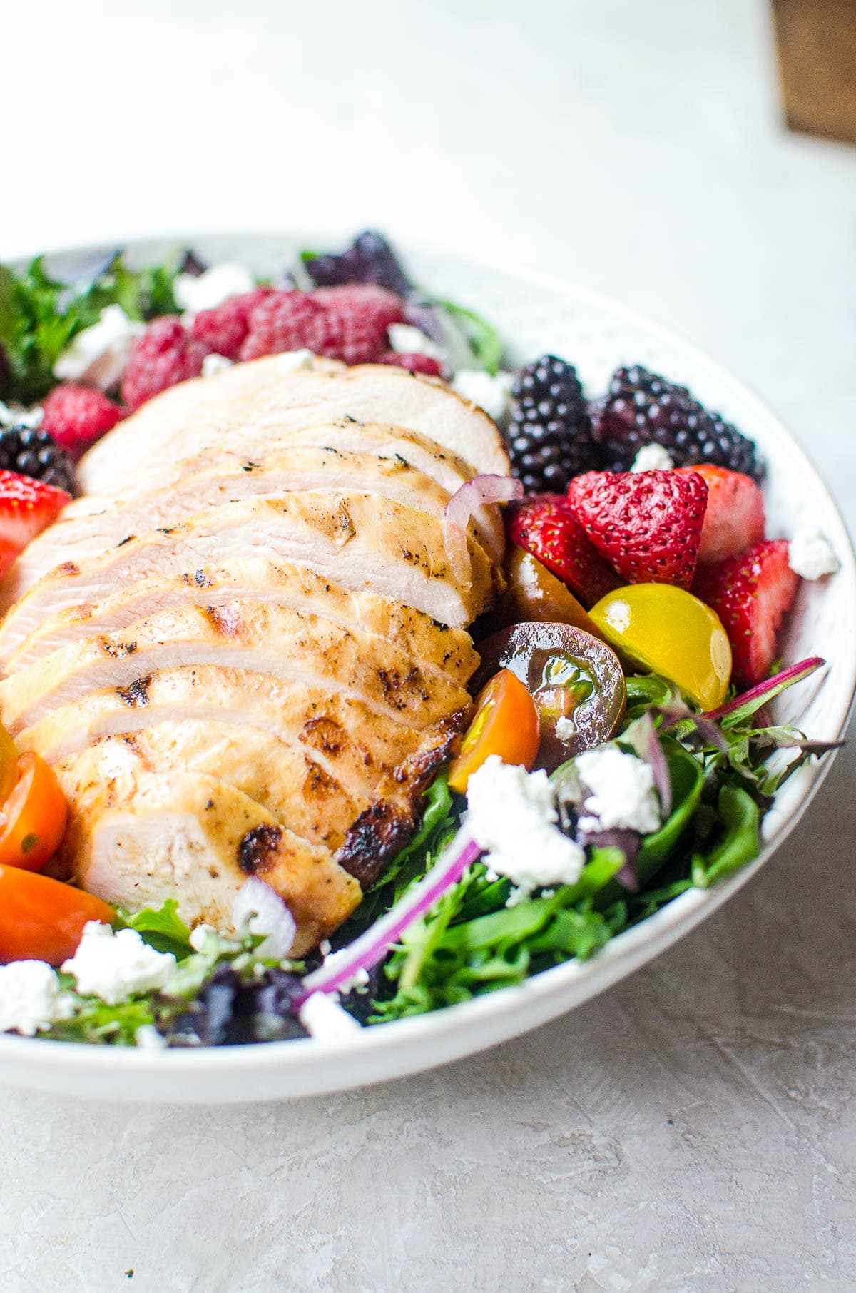 Sliced grilled chicken in a salad bowl with salad.